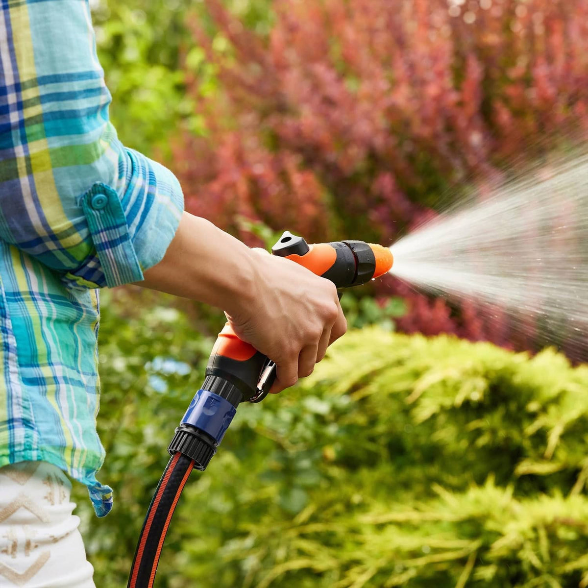 Blue garden hose quick connector on a spray hose with water misting