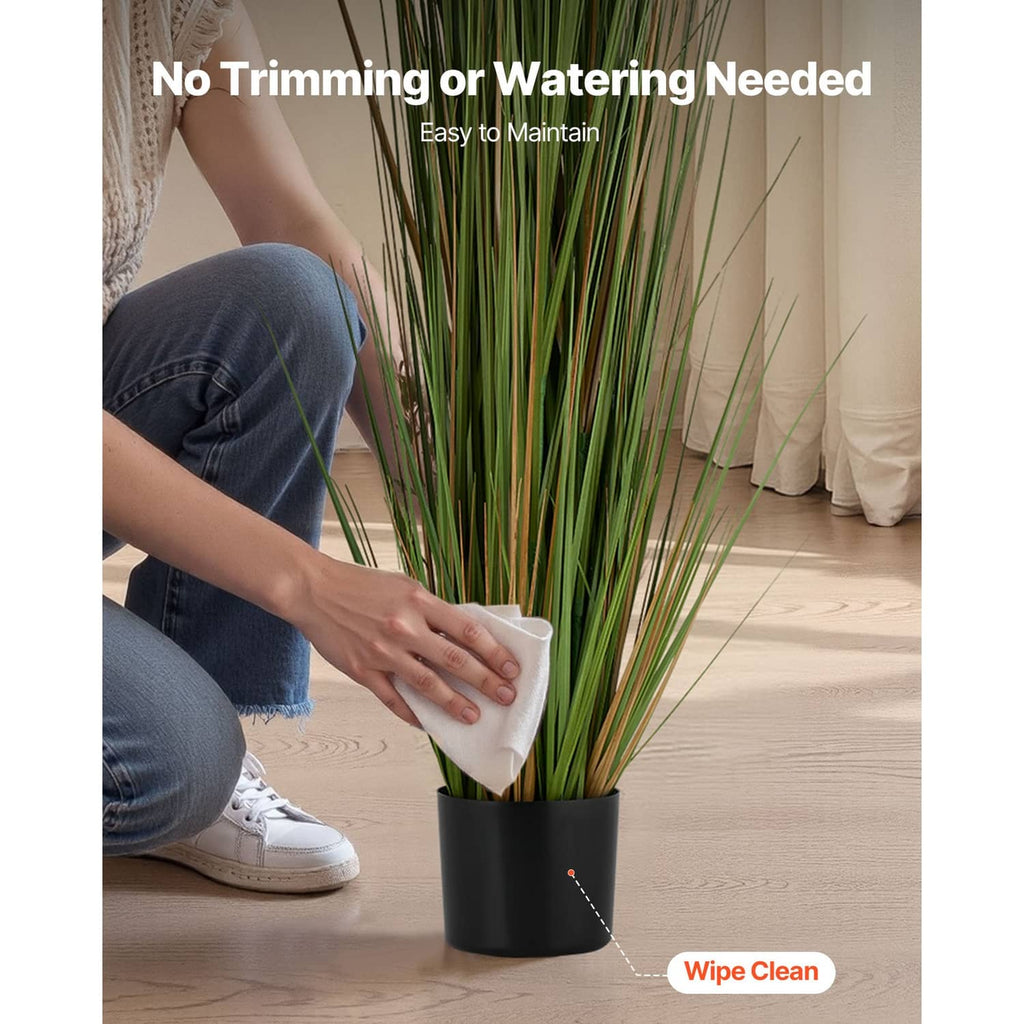 Artificial horsetail grass in black plastic pot, wiped clean with a white cloth
