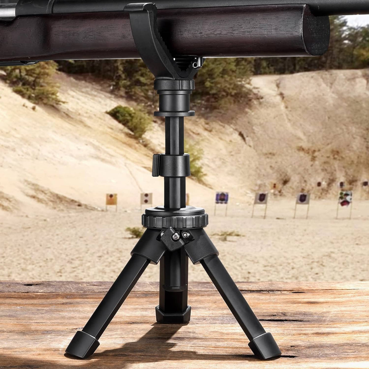 Black shooting tripod with V yoke rest supporting a rifle barrel