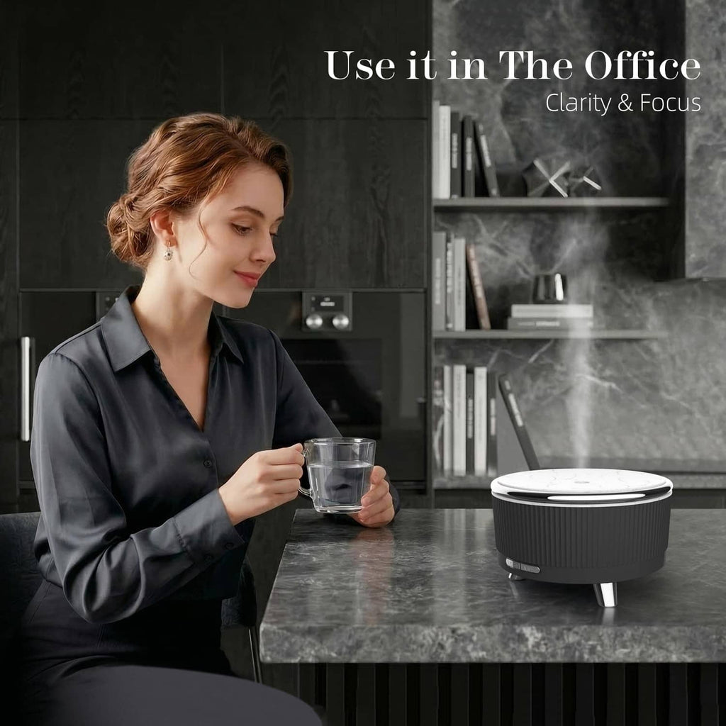 Black ultrasonic aromatherapy diffuser with control panel and metal feet, mist vent visible