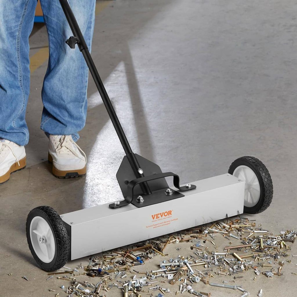 Magnetic sweeper picking up scattered metal pieces on a concrete floor