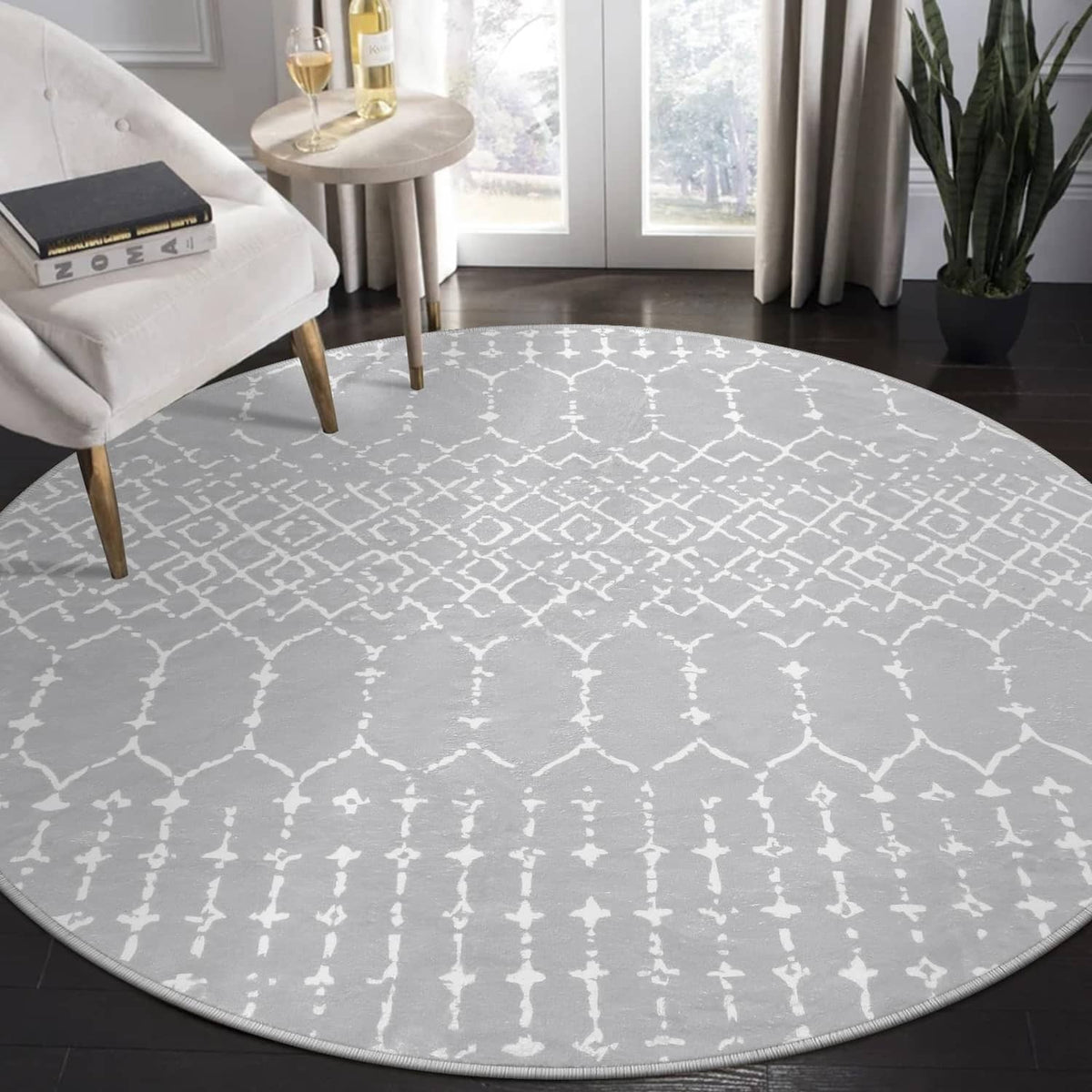 Grey round rug with white geometric Moroccan trellis pattern, low pile and stitched edge