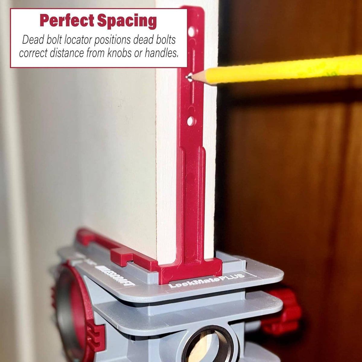 Door lock spacing jig with red guide plate holding alignment marker on a door