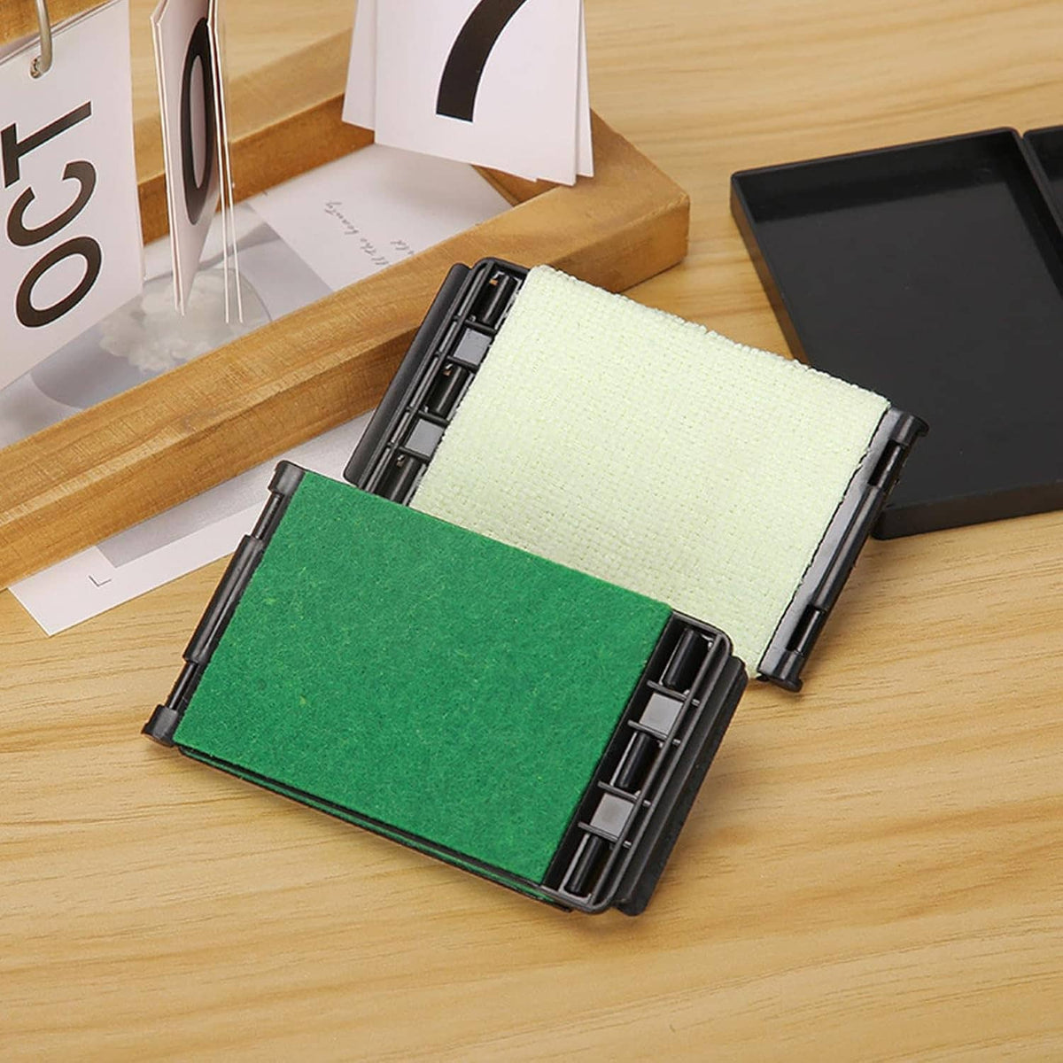 Guitar fretboard cloth cleaner tool with green and white pads in a black case