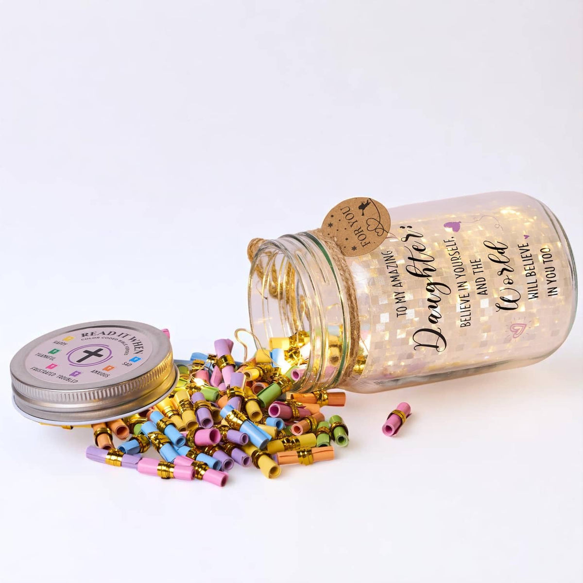 Clear mason jar lying on side with warm light, gold foil lid, and colorful coded beads