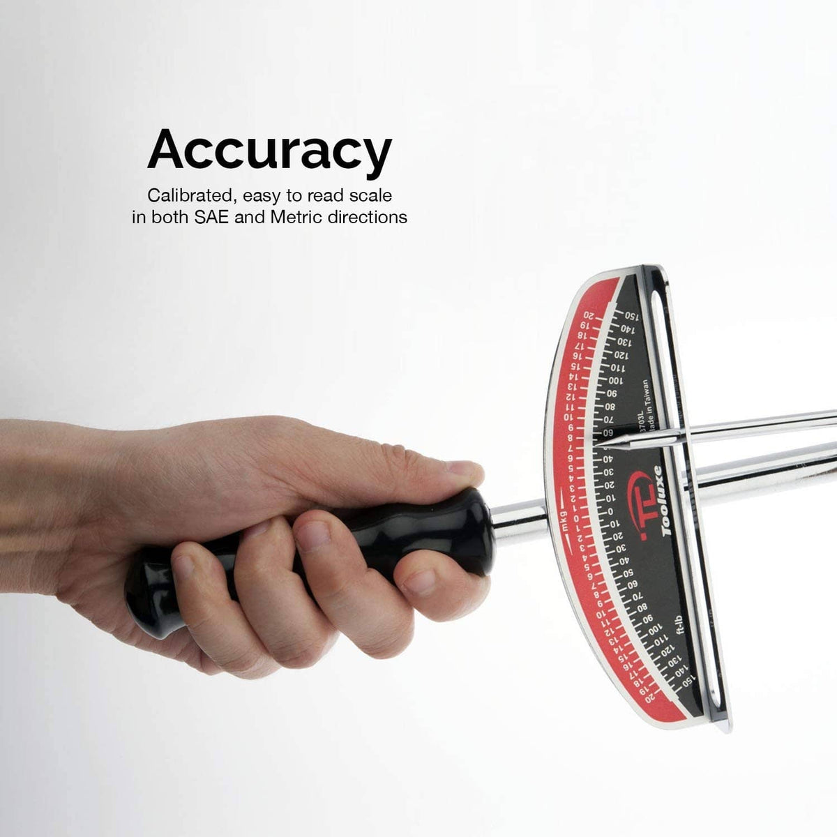 Torque wrench held in hand with red and black dual scale for SAE and metric