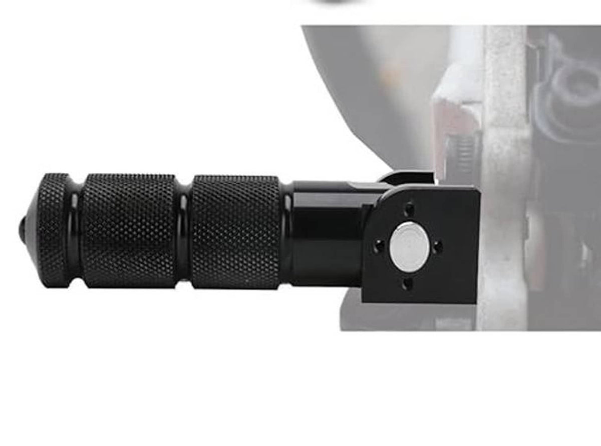 Black foldable foot peg with textured grip and mounting plate attached to bike