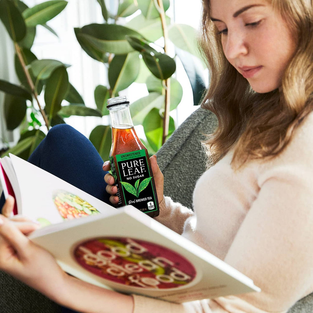 Pure Leaf unsweetened iced tea bottle held beside an open book