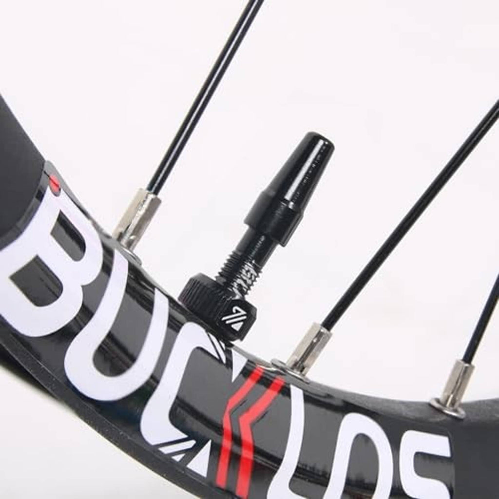 Black Presta valve stem installed on bike rim with metal core tip