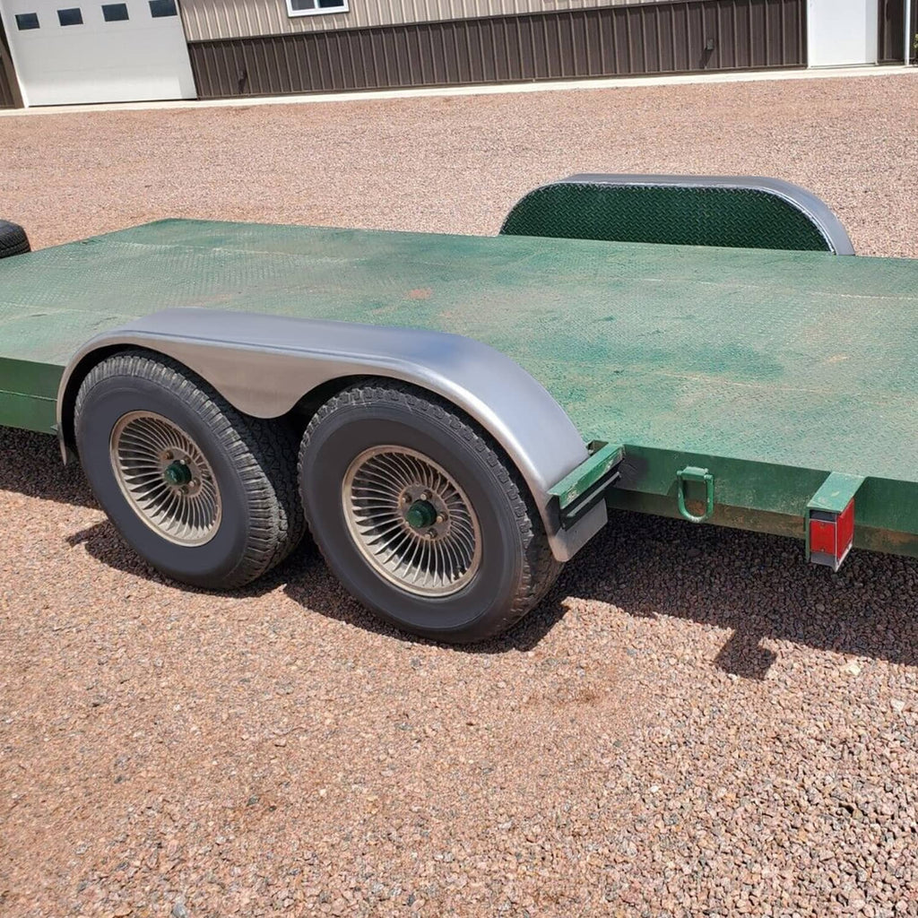 Angle view of silver steel trailer fenders installed beside dual wheels
