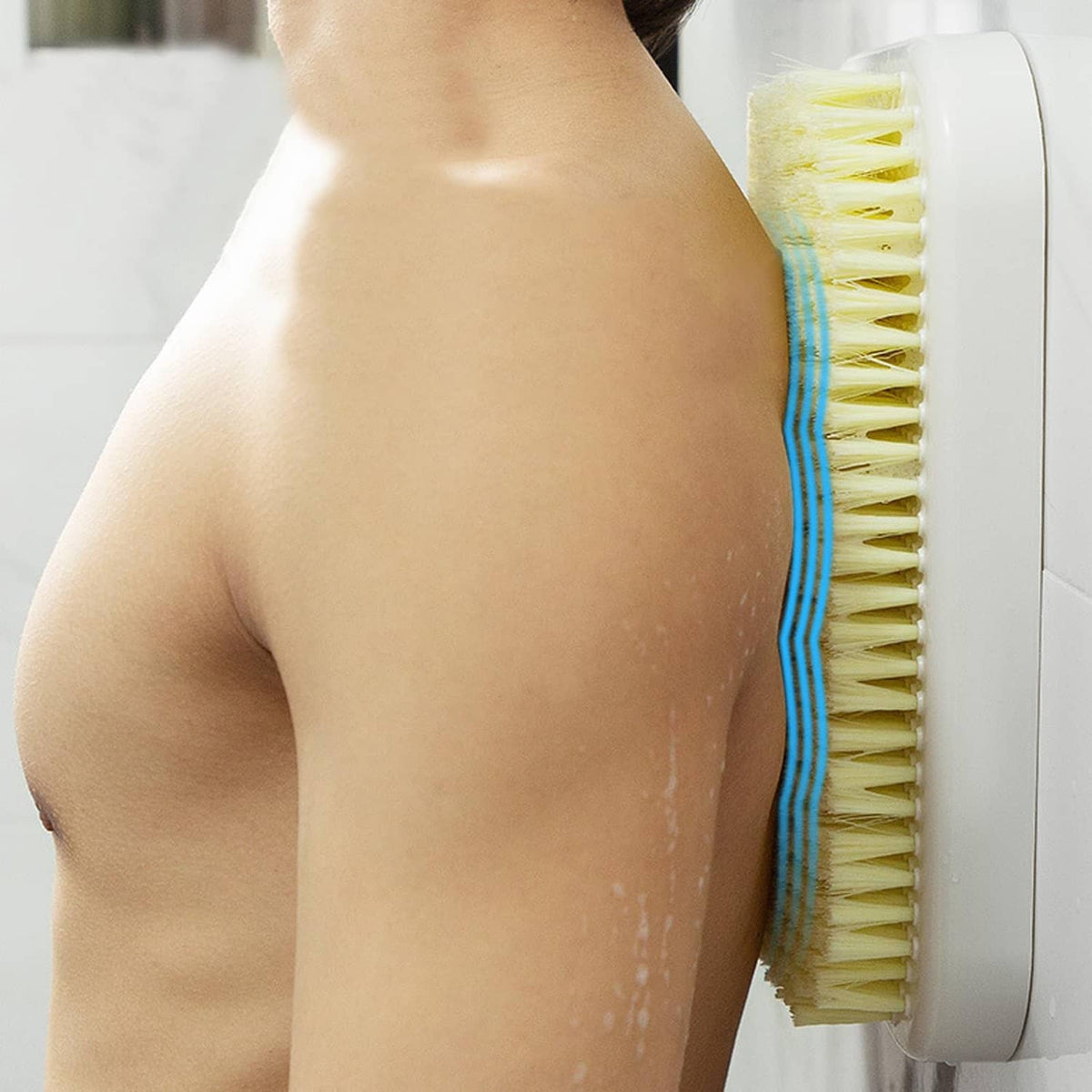 Wall-mounted back scrubber used on upper back; yellow bristle pad on white mount