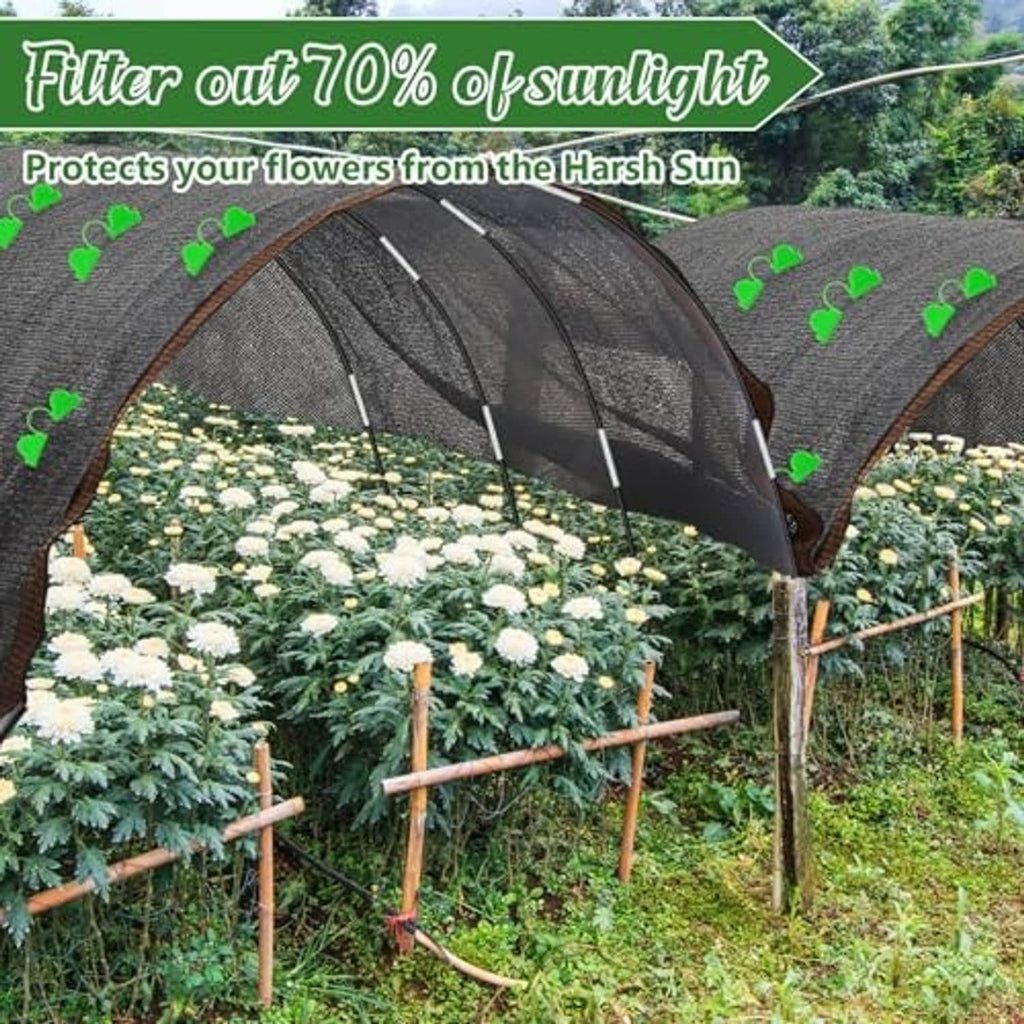 Black shade cloth tunnel canopy with arched hoops over blooming plants in garden