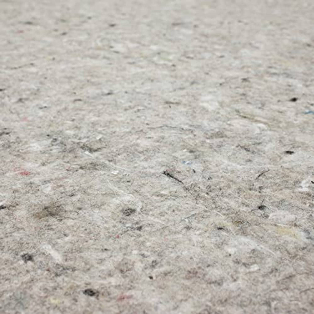 Top surface of light gray felt rug pad with speckles and embedded fibers