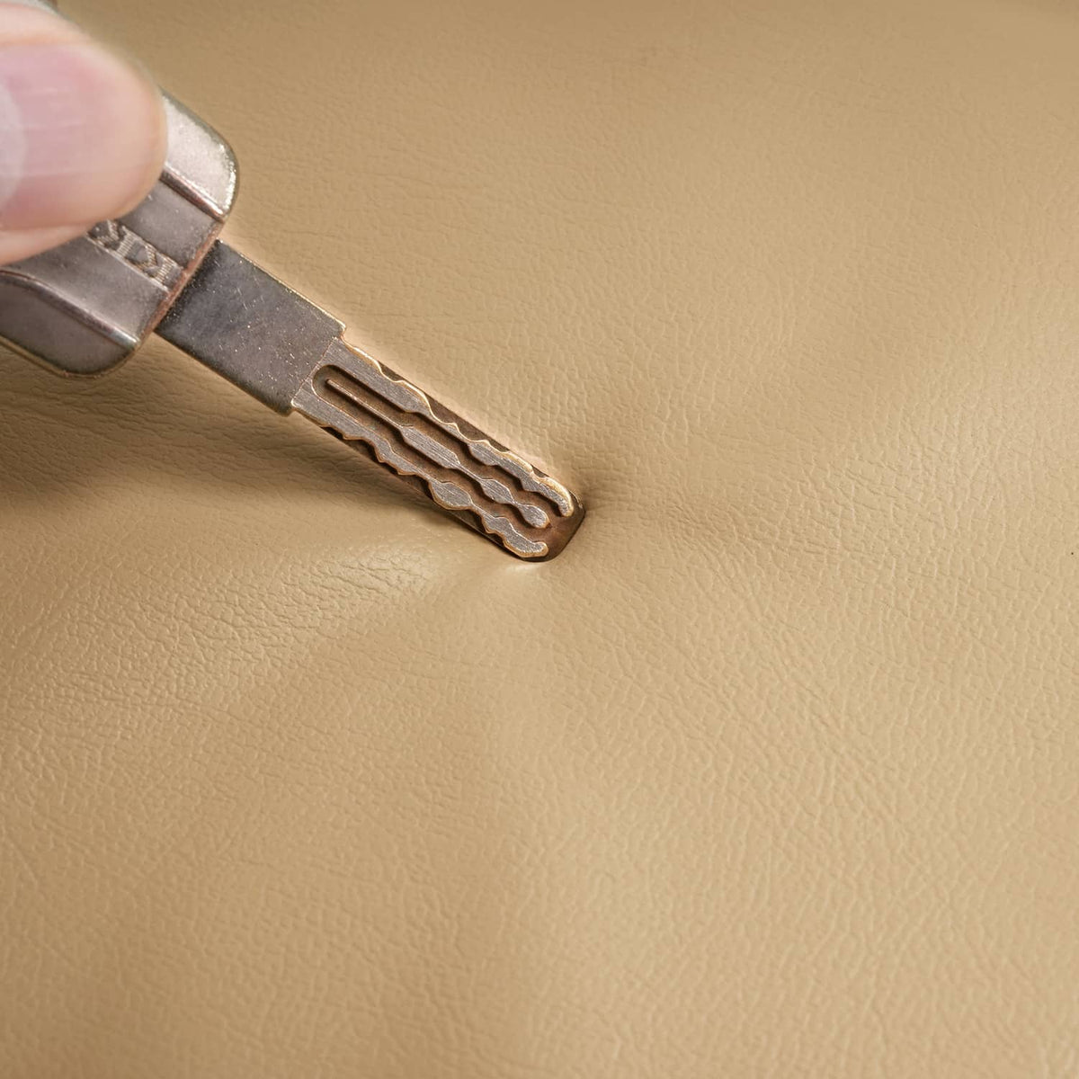 Tan seat back cover close-up, metal clip on stitched strap end