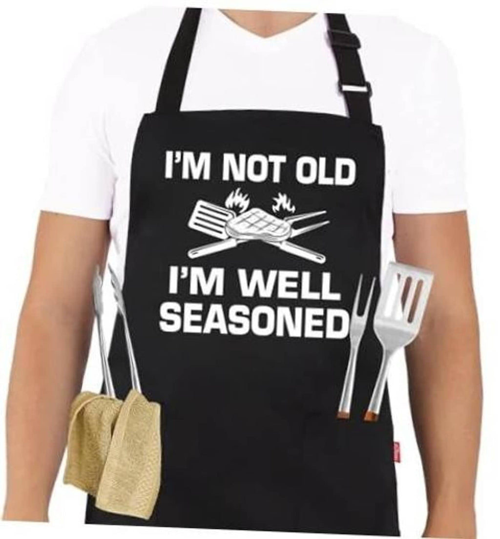 Black grilling apron with “I’M NOT OLD, I’M WELL SEASONED” graphic and utensil icons