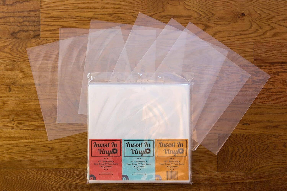 Stack of clear LP outer sleeves with one labeled pack on wooden floor