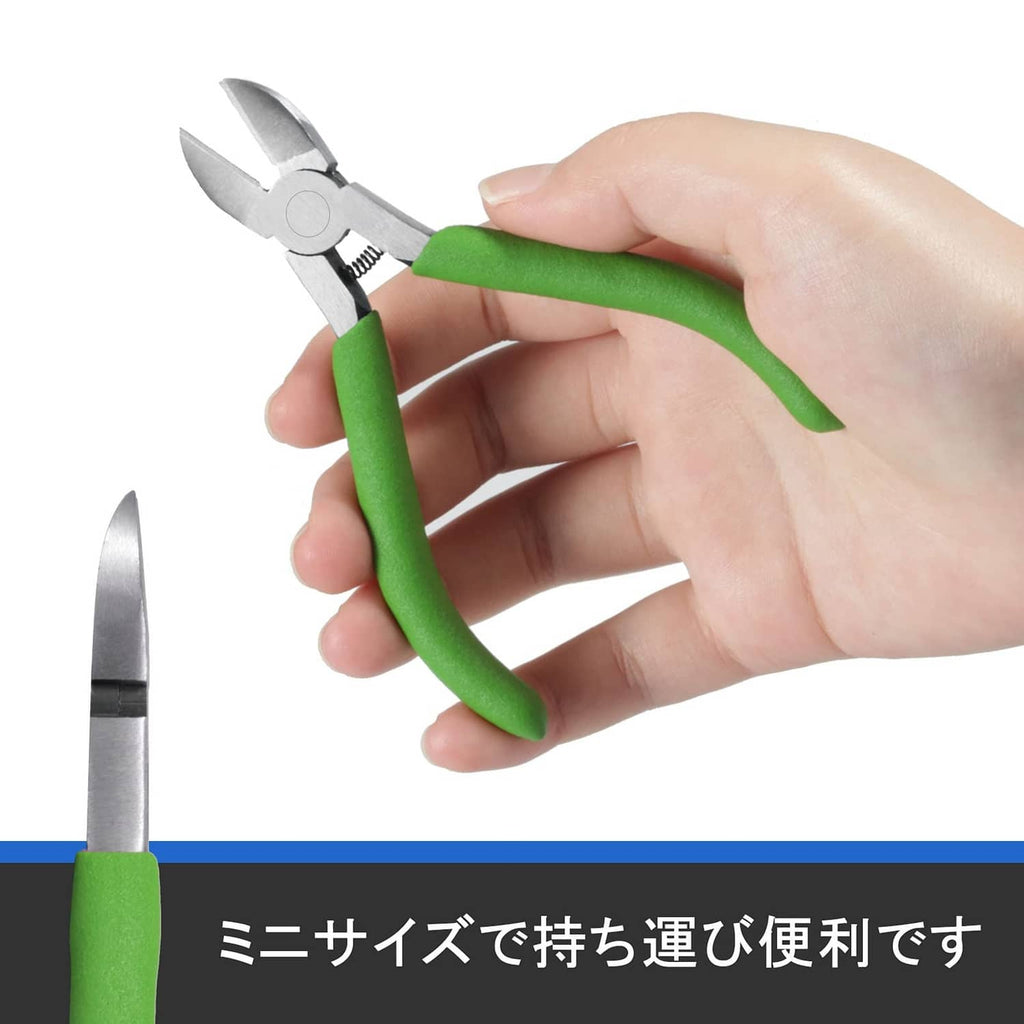 Small diagonal cutting pliers held in a hand with green grip handles