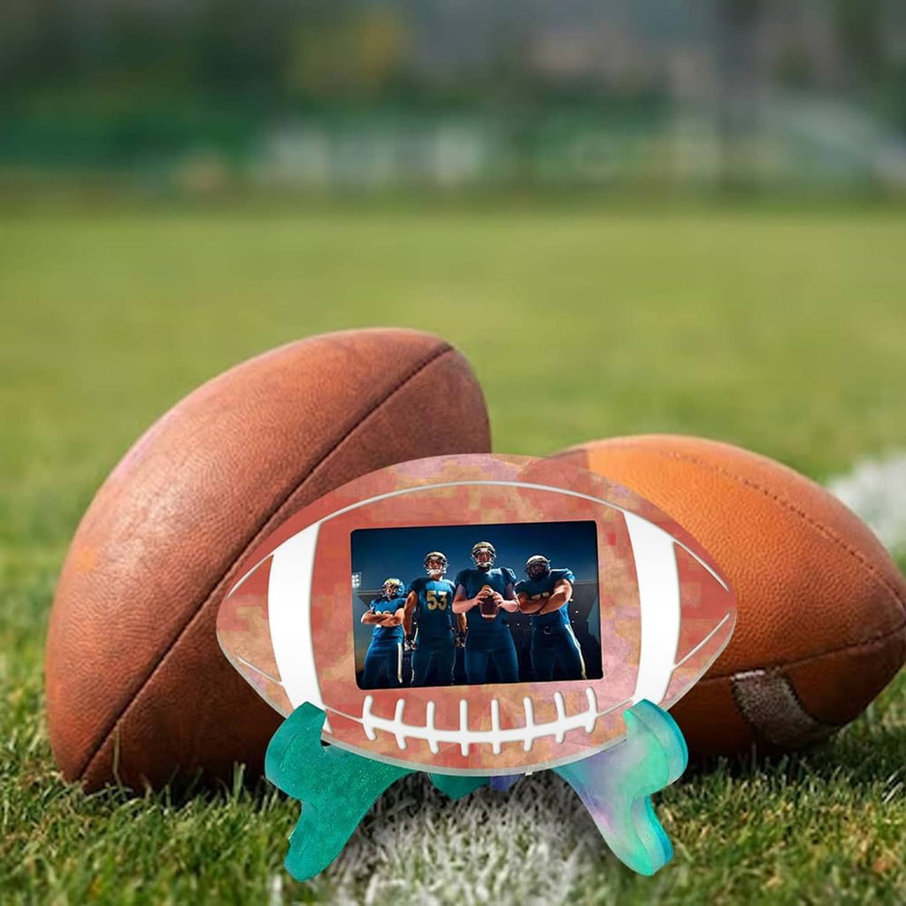 Football picture frame ornament sitting on grass with photo window and green feet