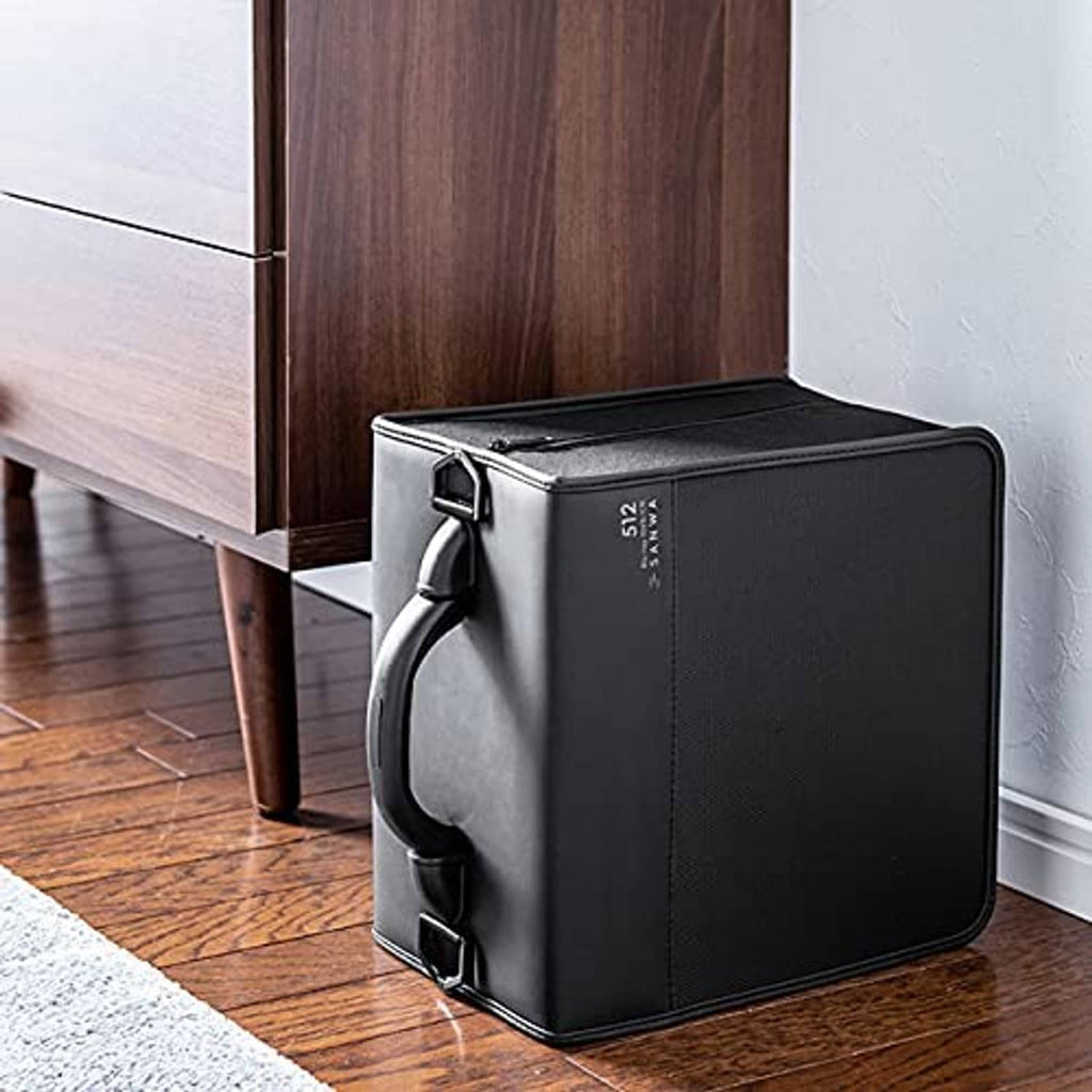 Black disc wallet with handle and two front straps, placed upright on a floor