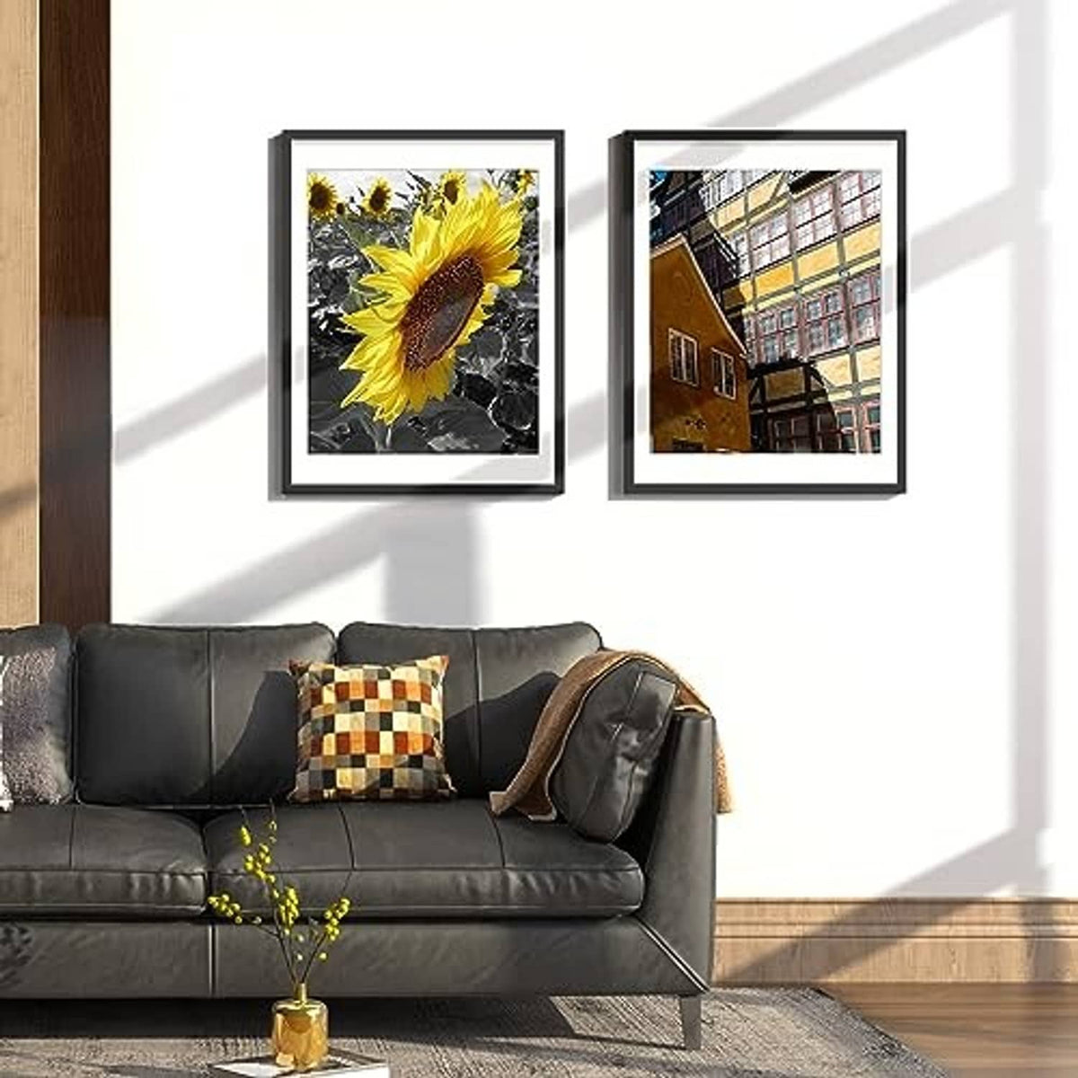 Two black picture frames with white mats on a living room wall