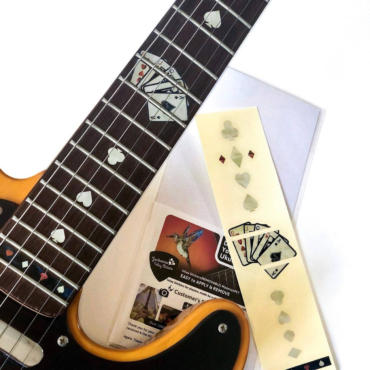 Set of white playing-card inlay decals on guitar fretboard