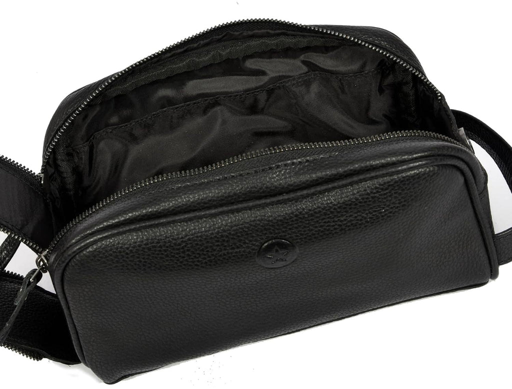 Black leather toiletry pouch open with visible inner pockets and zipper tracks