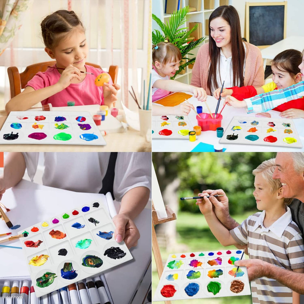 White watercolor paint tray palette on table with colorful paint blobs and brushes