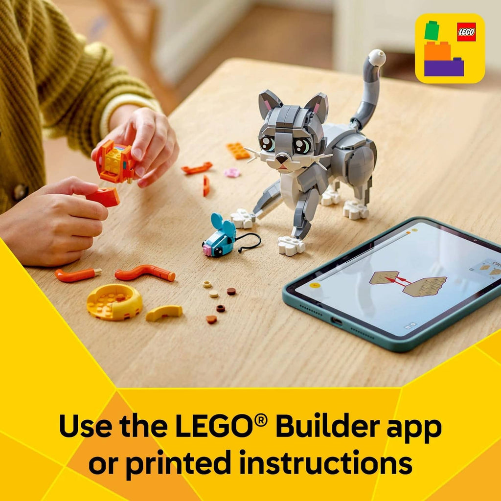 Built LEGO grey cat figure on the floor with orange pieces as a child assembles