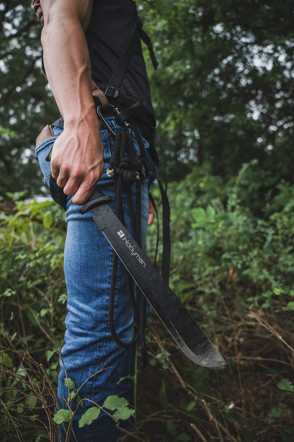 Hooyman bush machete carried in hand with green handle and long curved blade