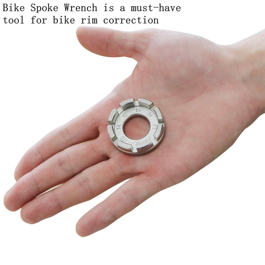 Bike spoke wrench held in palm, silver metal ring with size markings