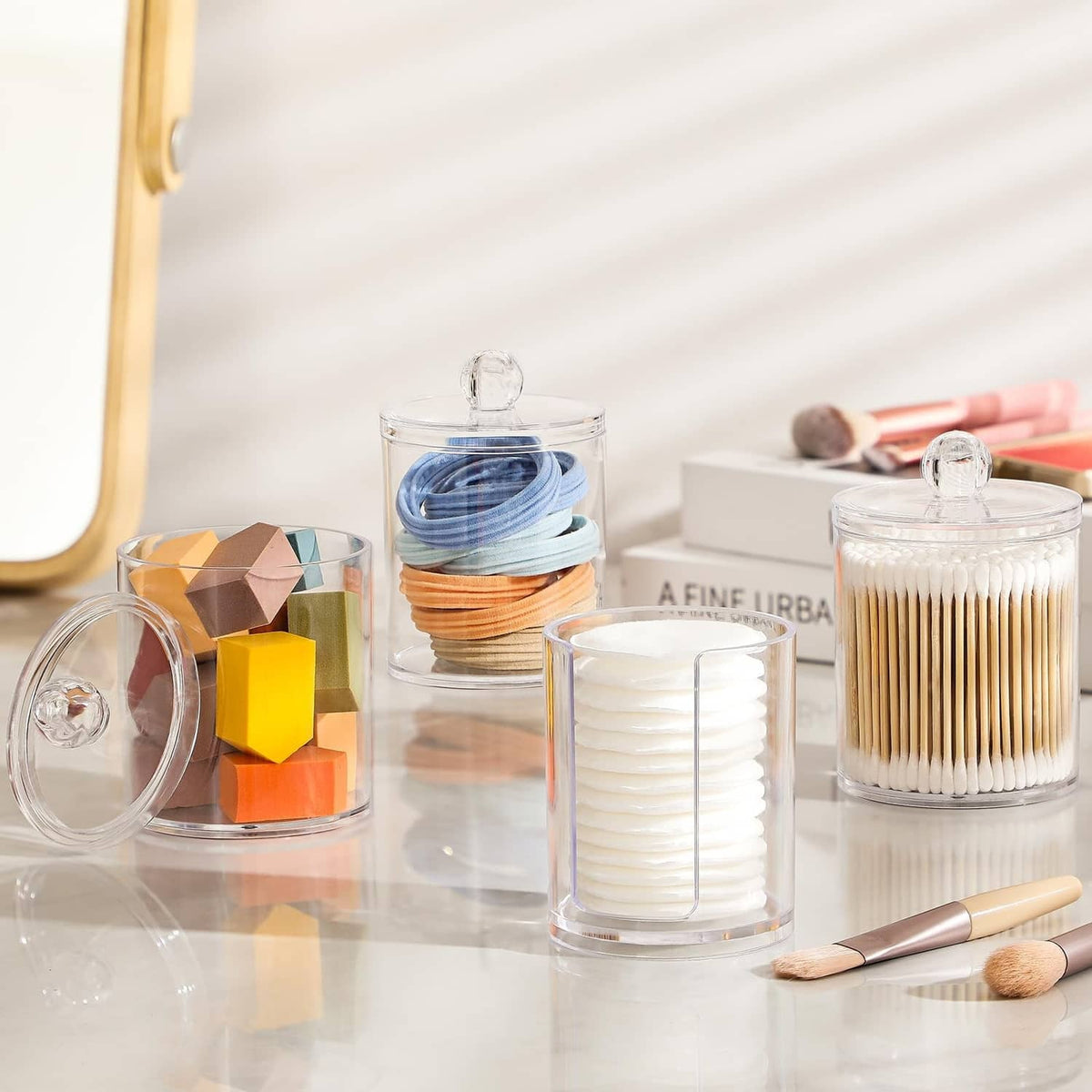 Clear acrylic cotton swab and pad holders with dome lids and stacked supplies