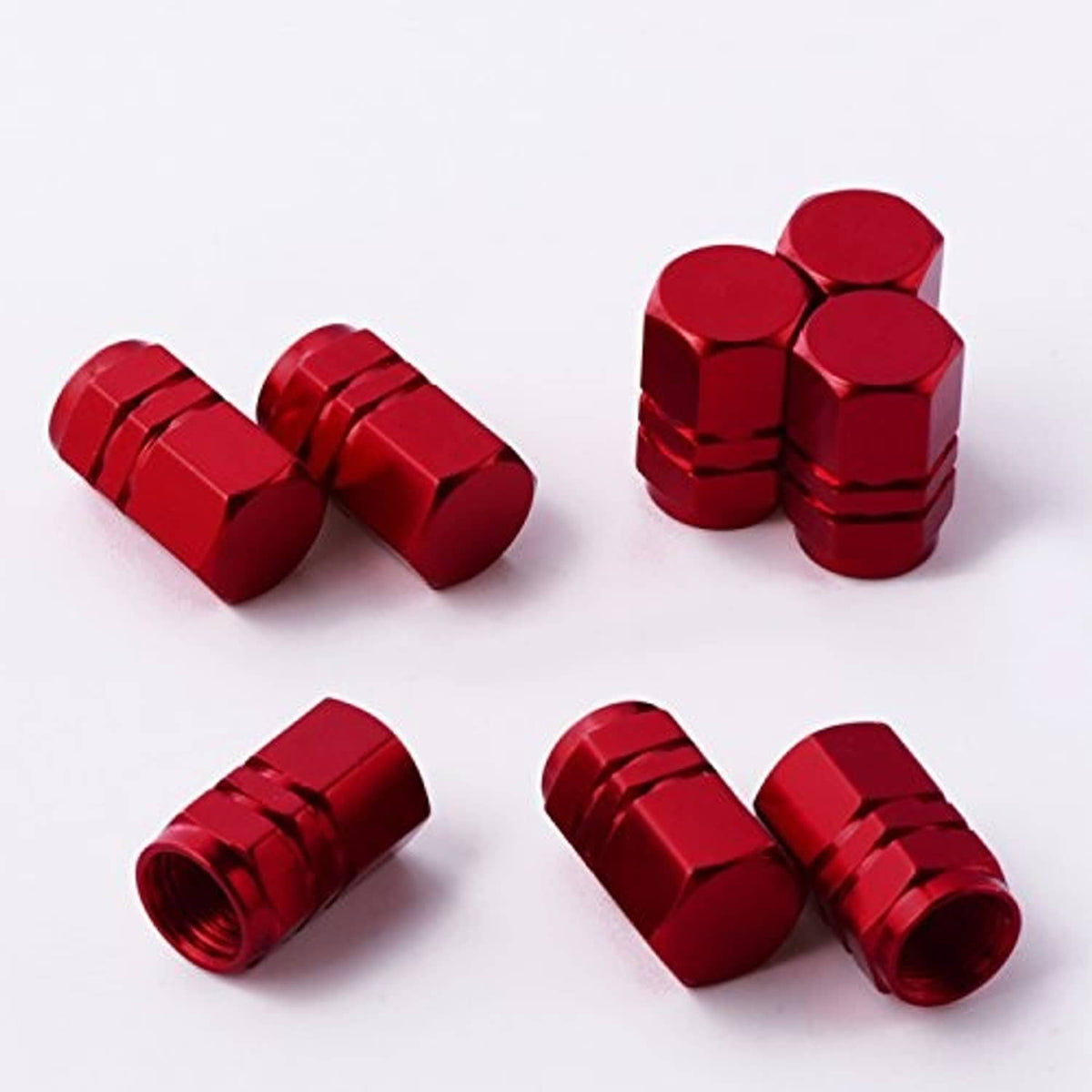 Red metal tire valve caps in two groups, hex tops and ridged side details