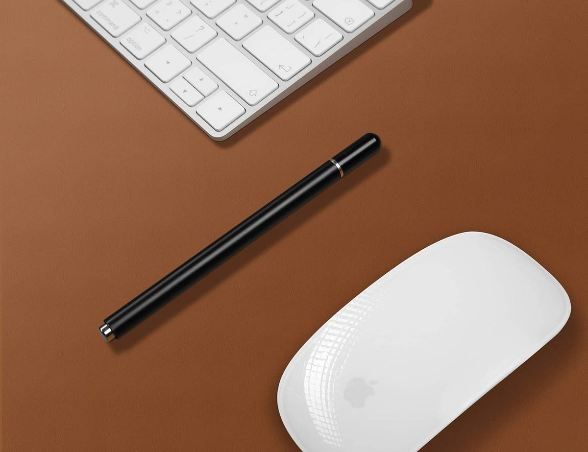 Brown leather desk pad surface with keyboard, pen, and white wireless mouse on top.