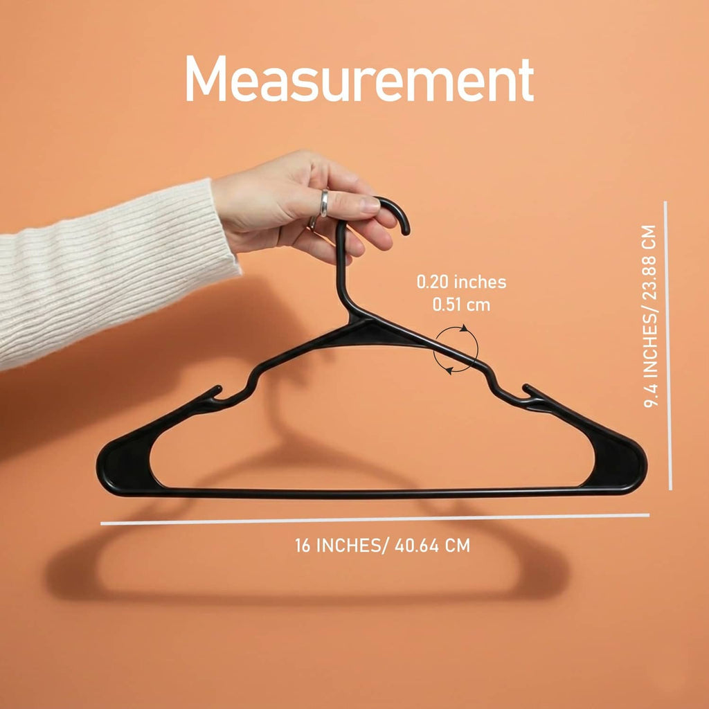 Black plastic hanger held in a hand with size measurement markings.