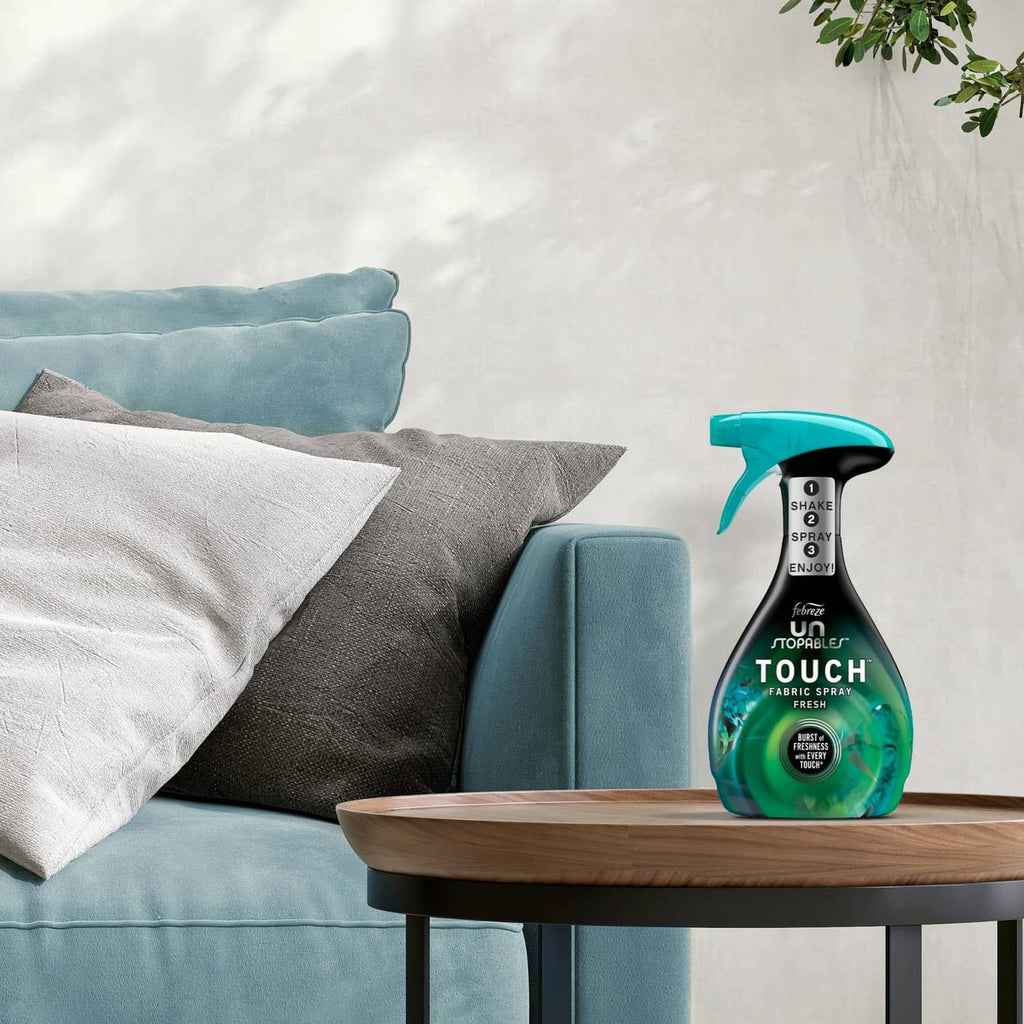 Teal trigger fabric spray bottle on wooden side table with pillows