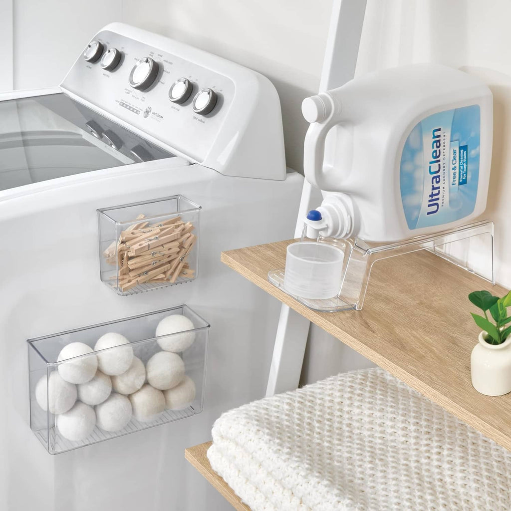 Laundry detergent holder with white dispenser and clear drip tray on countertop.