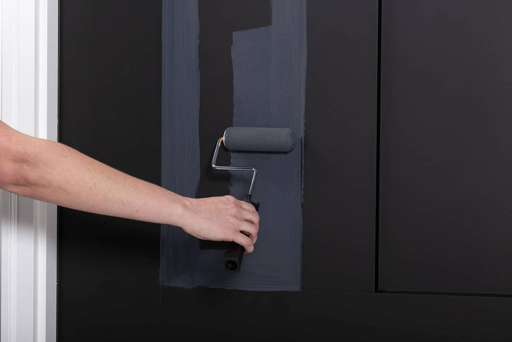 Dark navy door coated with satin paint using a paint roller
