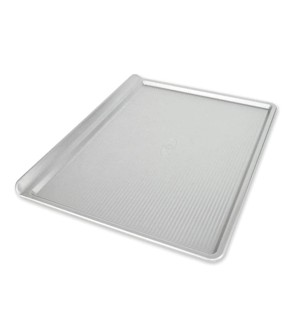 Large silver nonstick cookie sheet with raised rim and striped texture