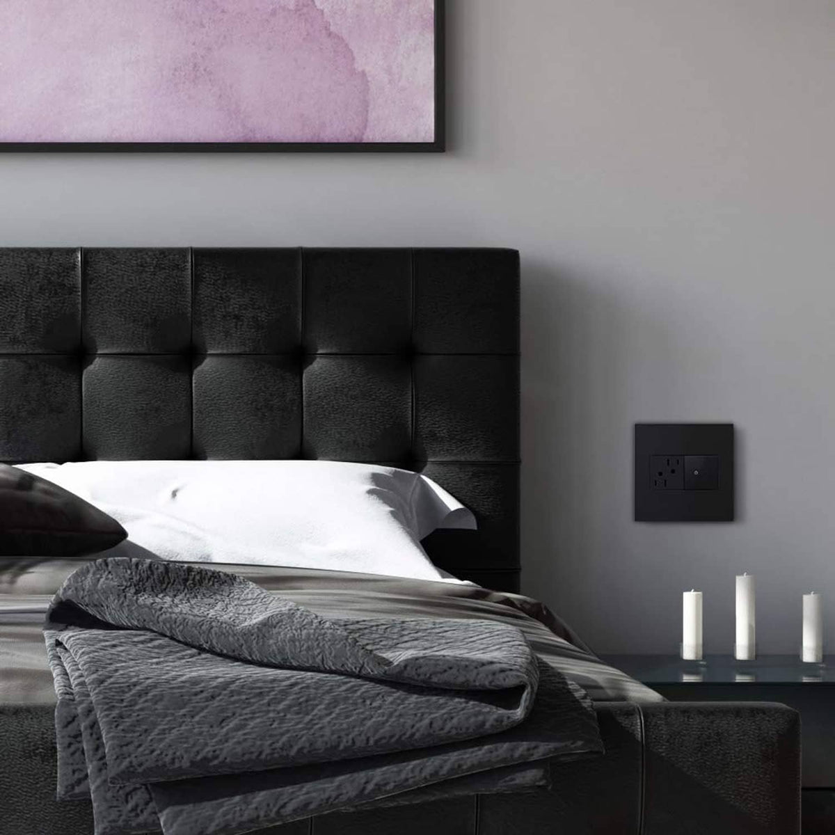 Graphite 2-gang wall plate outlet on a smooth gray bedroom wall near a bed