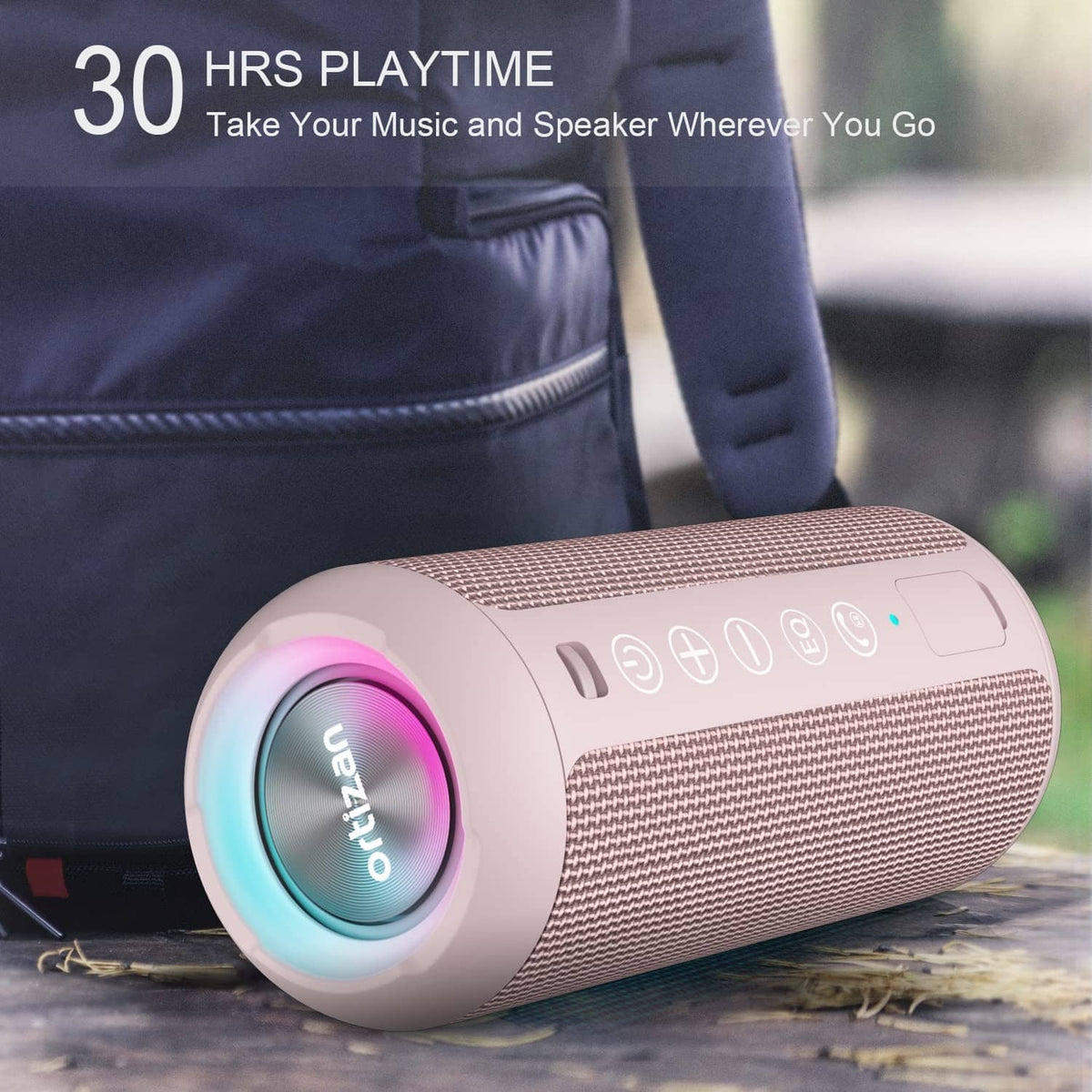 Pink portable Bluetooth speaker with glowing light ring, placed on outdoor ground