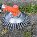 Wire weed brush trimmer head with circular metal guard and steel bristles on orange housing