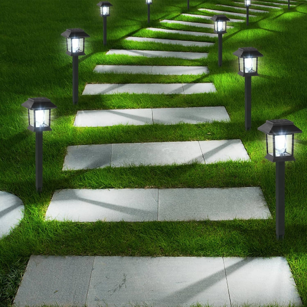 Set of solar path lights with black lantern heads, lighting white walkway slabs