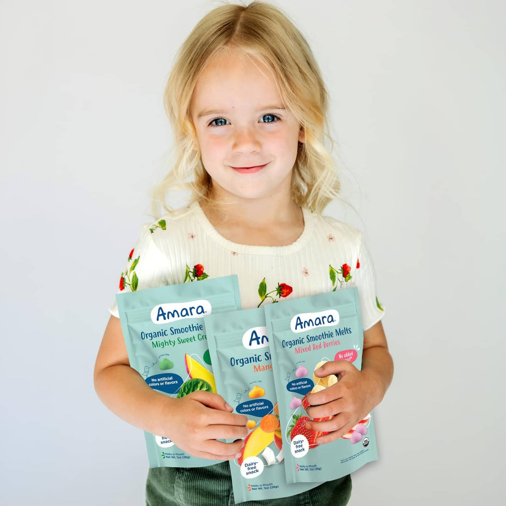 Toddler holding Amara organic smoothie melts variety pack pouches