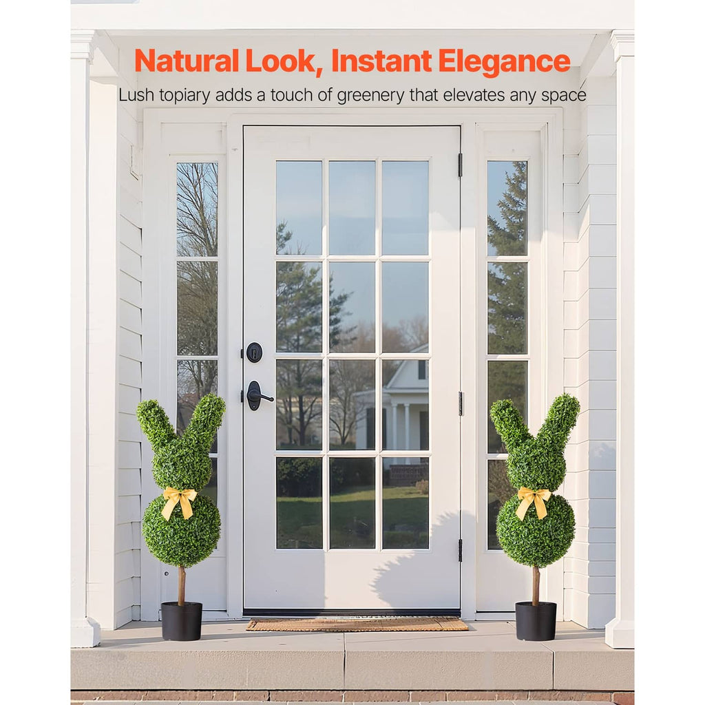 Pair of artificial bunny-shaped boxwood topiaries with yellow bows in black pots.