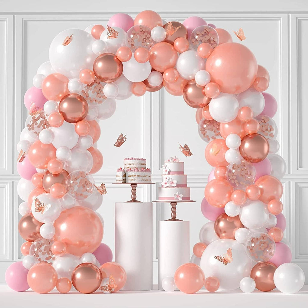 Pink and white balloon arch with round balloons and cake table background