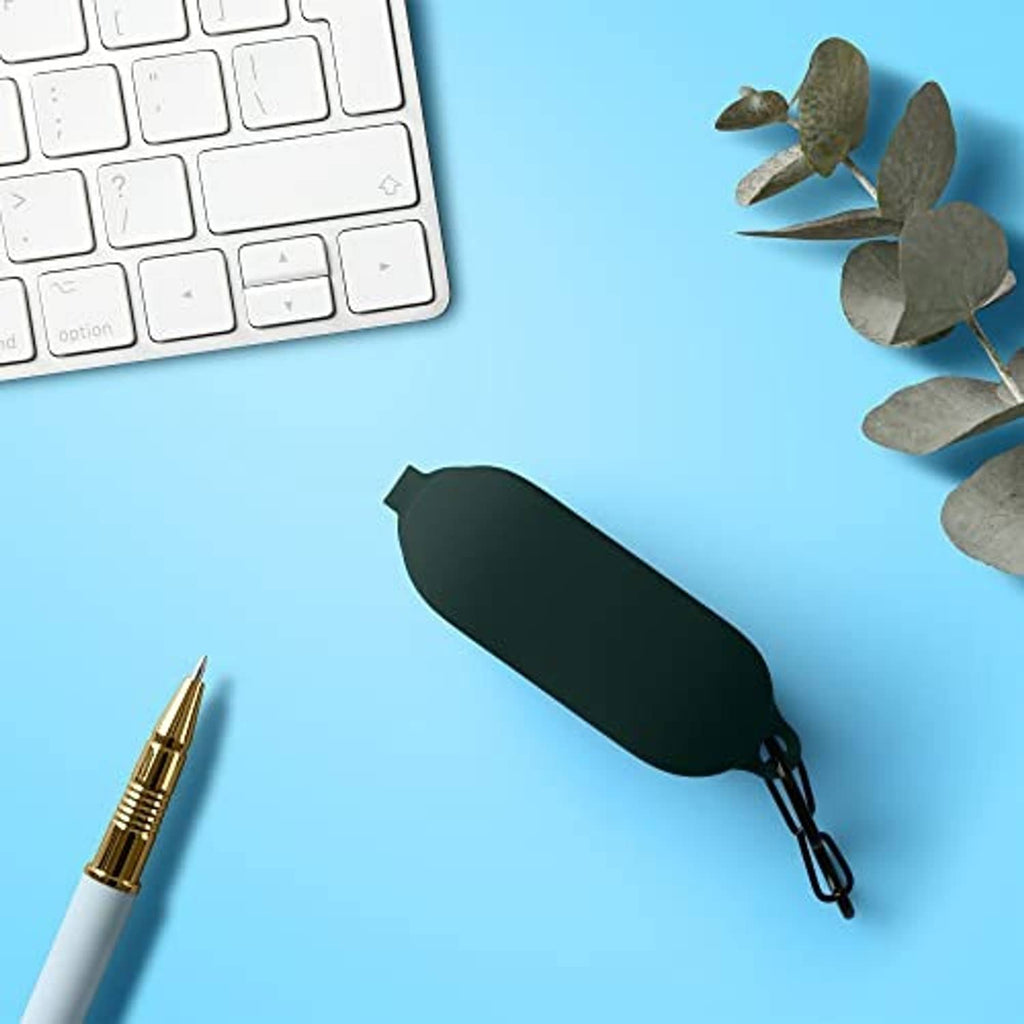 Dark green silicone earbud case lying on a desk near small accessories