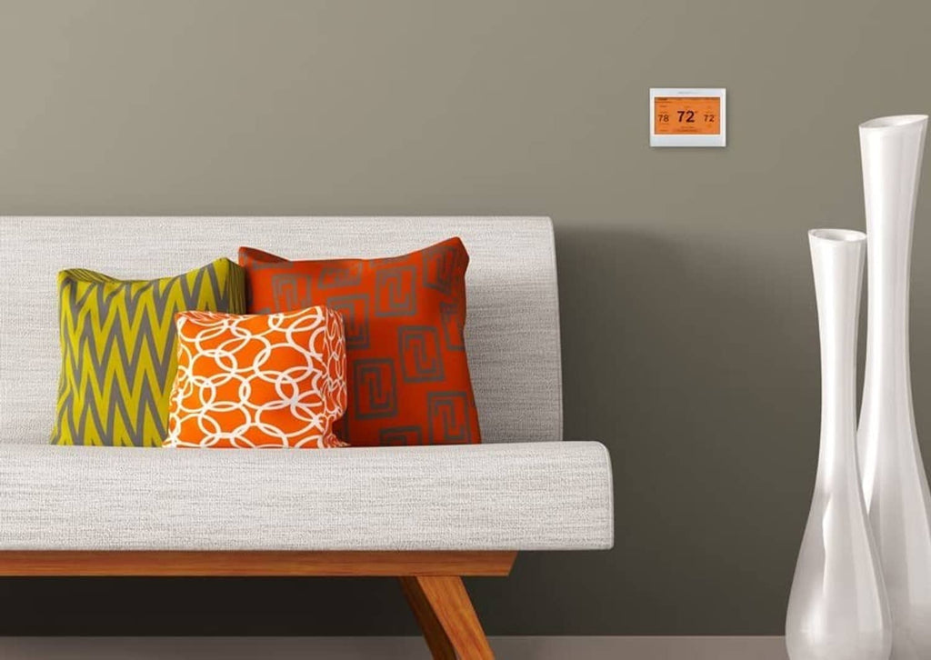 Wall-mounted white smart thermostat with orange backlit display