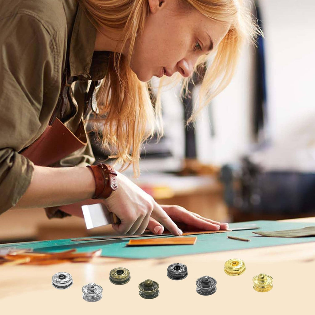 Metal snap button fastener kit with 12mm leather snaps, laid out on a work surface