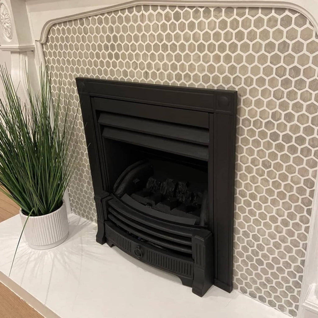 Honeycomb-pattern fireplace screen with black front and surrounding tile wall