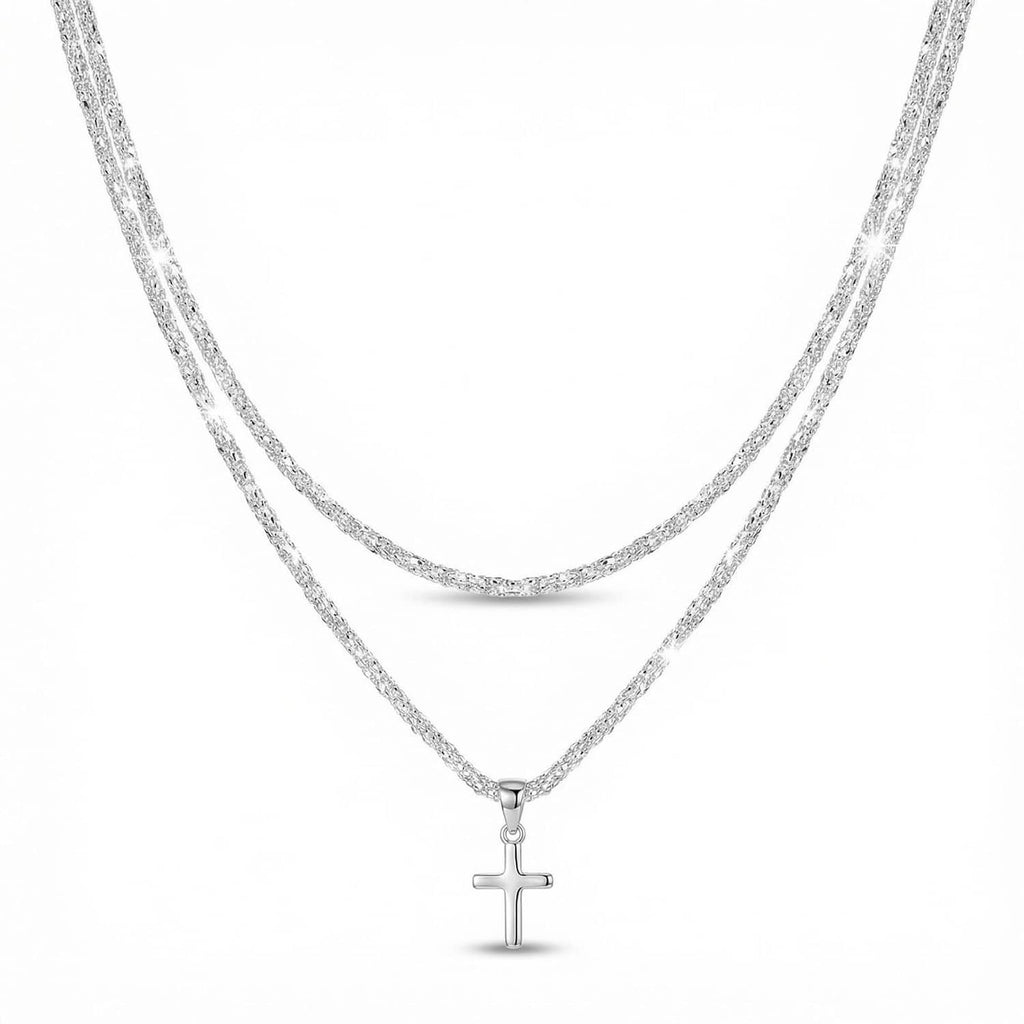 Silver-tone layered chain necklace with a small cross charm pendant